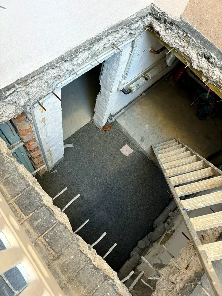 Geöffnete Bodenplatte mit freigelegter Bewehrung für die Aufzugsunterfahrt, Leerbachstraße
