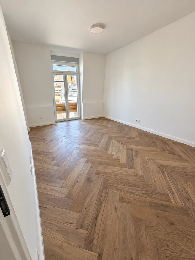 Wohnraum mit Fischgrätparkett nach der Kernsanierung, Rennbahnstraße