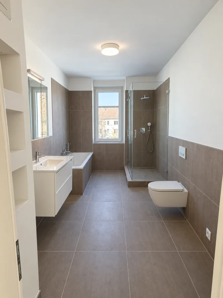 Neu ausgebautes Bad mit Wanne, bodenebener Dusche und großformatigen Fliesen
