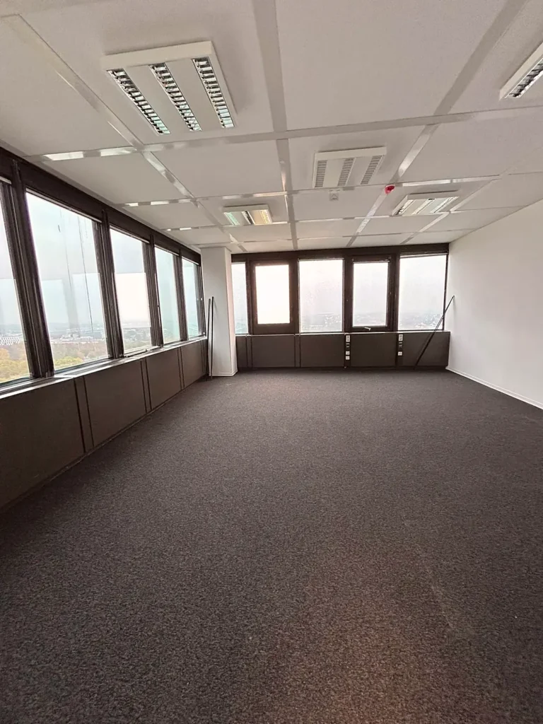 Großer Büroraum mit Fensterfront und neuem Teppichboden